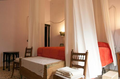 a bedroom with a bed and two chairs and a window at BORGO PETELIA, Casa Mannarino, suite Lucrezia in Strongoli