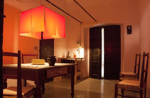 una sala da pranzo con tavolo e lampada di BORGO PETELIA, Casa Mannarino, suite Lucrezia a Strongoli