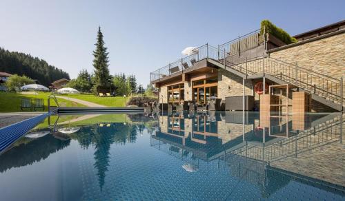 ein Haus mit Pool davor in der Unterkunft Hotel Kroneck in Kirchberg in Tirol