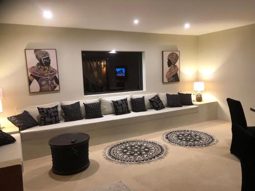 a living room with a couch with pillows on it at Villa Le Petit Paradis Saly Boutique Hotel in Ngaparou