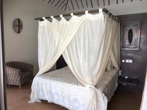a bedroom with a bed with a canopy at Villa Le Petit Paradis Saly Boutique Hotel in Ngaparou