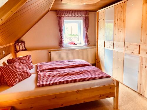 a small room with a bed in a attic at Ferienhof Hintergrabenbauer in Spital am Pyhrn