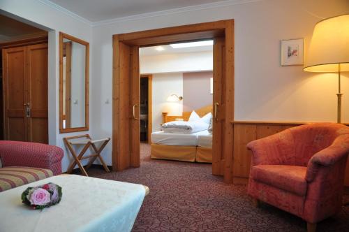 a hotel room with a bed and a living room at Alpenrose Kufstein in Kufstein