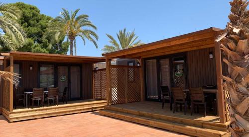 ein Haus mit einer Terrasse mit Stühlen darauf in der Unterkunft Camping Armanello in Benidorm