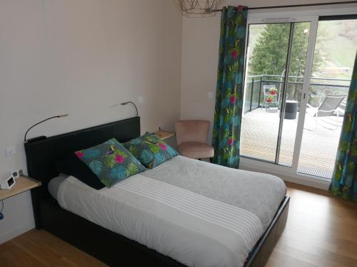 a bedroom with a bed and a sliding glass door at C4 - Résidence La Montille in Le Mont-Dore