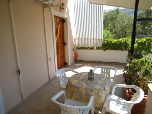 a table and chairs on a patio with a table and a window at Villa Xenos in Kalamaki