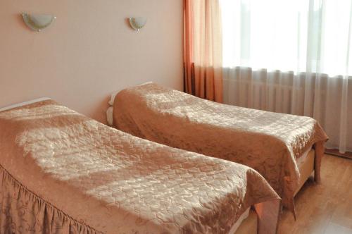 a room with two beds and a window at Voznesenskaya Hotel in Ivanovo