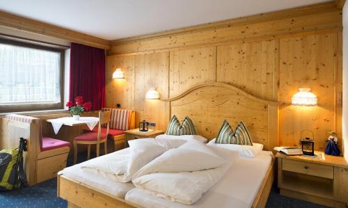 a bedroom with a large bed and a table at Activehotel Diana in Siusi