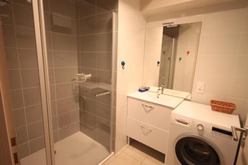 a bathroom with a shower and a washing machine at C5 - Résidence La Montille in Le Mont-Dore