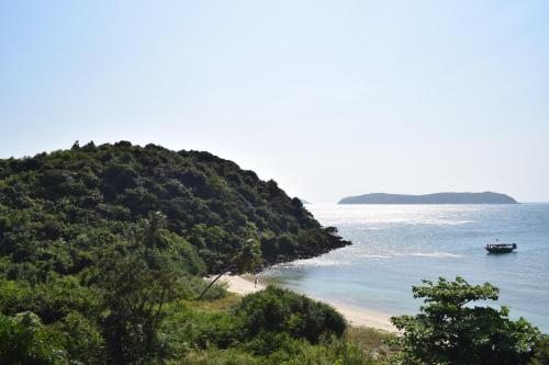 a boat in the water next to a beach at Cham Island Smiles Homestay in Tân Hiệp