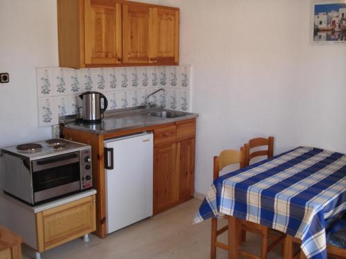 a kitchen with a sink and a stove and a table at Marianna Apartments in Agia Pelagia