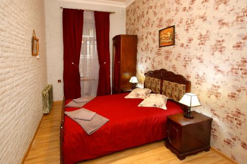 um quarto com uma cama vermelha e um cobertor vermelho em Apart Hotel Qetostan em Tbilisi