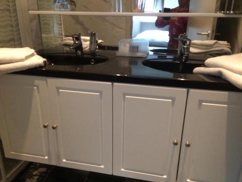 a bathroom with a sink and a black counter at B&B Don Genaro in Dilsen-Stokkem