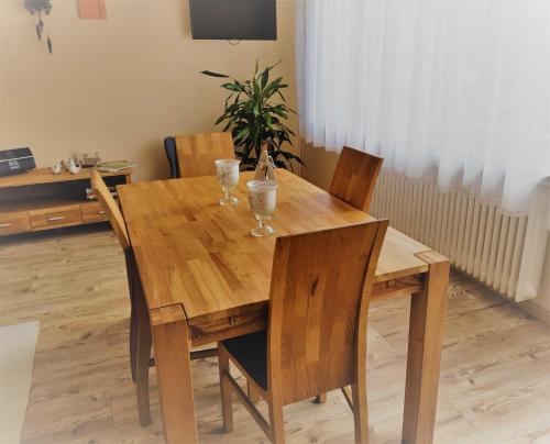 uma mesa de jantar em madeira com dois copos em Ferienwohnung Rombachs Spatzennest em Herbolzheim