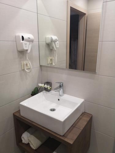 a bathroom with a white sink and a mirror at Rooms Vukušić in Rab