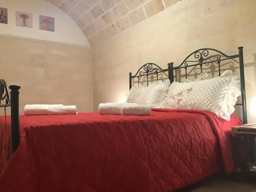 1 dormitorio con 2 camas con sábanas rojas y almohadas blancas en Dimora San Biagio, en Veglie