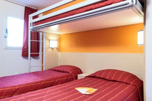 duas camas num quarto de hotel com lençóis vermelhos em Premiere Classe Marne La Vallee - Saint Thibault Des Vignes em Saint-Thibault-des-Vignes