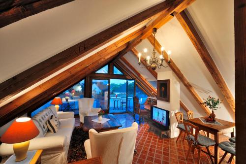ein Wohnzimmer mit weißen Möbeln im Dachgeschoss in der Unterkunft Herberge an der Nikolauszeche in Purbach am Neusiedlersee