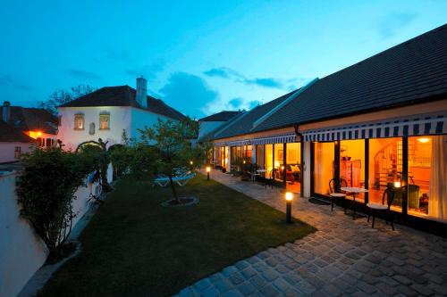 ein Innenhof eines Hauses mit Bänken und Lichtern in der Unterkunft Herberge an der Nikolauszeche in Purbach am Neusiedlersee