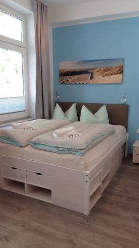 a white bed in a room with a window at Gästehaus Twee Linden in Warnemünde