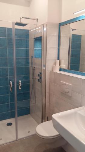 a bathroom with a shower and a toilet and a sink at Gästehaus Twee Linden in Warnemünde