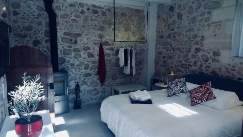 a bedroom with a bed and a stone wall at The Manor - Old Town Rethymno, Crete in Rethymno Town