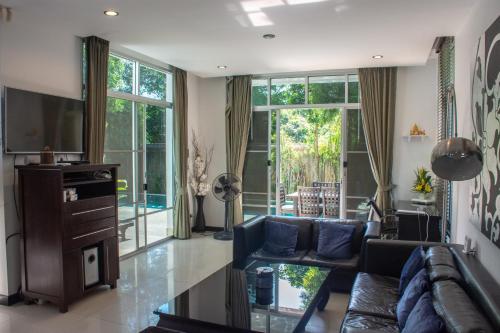 a living room with a couch and a tv at Comfosya BBQ Pool Villa near Jomtien Beach in Na Jomtien