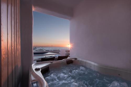 a bath tub in a room with a view at Riva Suites - Adults Only in Mikonos