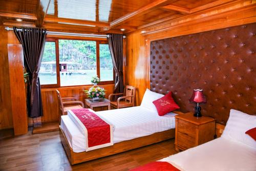 1 Schlafzimmer mit 2 Betten und einem großen Fenster in der Unterkunft Cat Ba Bay Cruises in Cát Bà