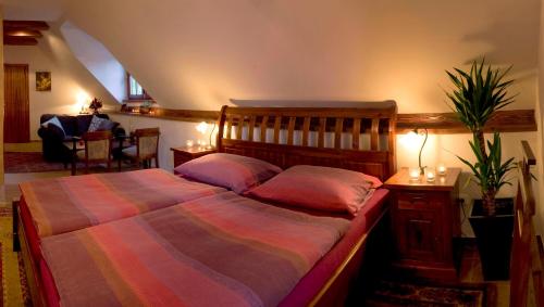 a bedroom with a large bed with pink pillows at Penzion Rozmarýn in Vsetín
