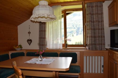 ein Esszimmer mit einem Tisch, Stühlen und einem Fenster in der Unterkunft Landhaus Trista in Damüls