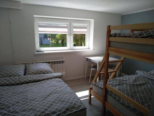 a bedroom with two bunk beds and a desk at Noclegi NAD NILEM in Zator