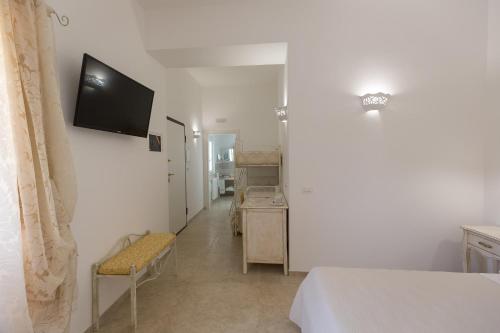 a room with a bed and a television on a wall at Dimora San Quirico - bed e breakfast - Cisternino in Cisternino
