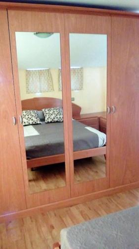a bedroom with a bed in a cabinet with mirrors at EL TRASTERO in Santa Marta de Tormes