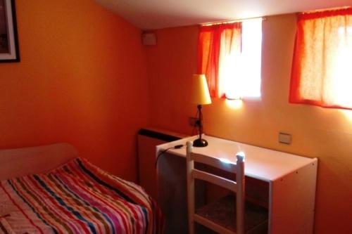 a small room with a desk with a lamp and a bed at EL TRASTERO in Santa Marta de Tormes