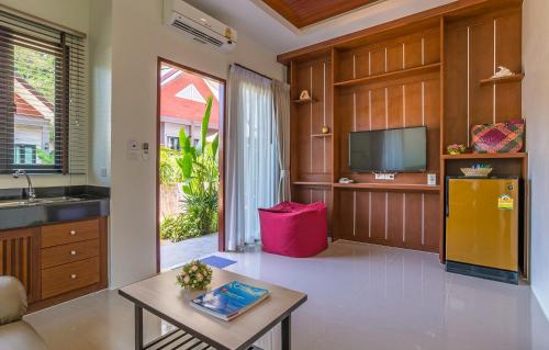 a living room with a tv and a table at The Scene Cliff View Villas in Ao Nang Beach