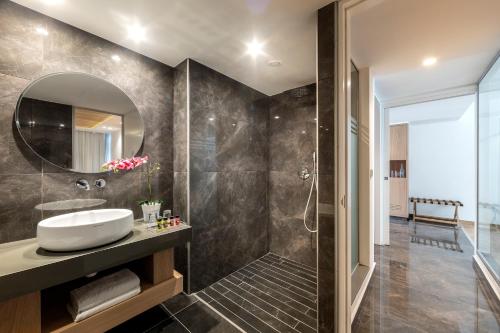 a bathroom with a sink and a mirror at Limanaki Beach Hotel & Suites in Ayia Napa