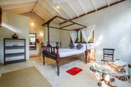 Schlafzimmer mit einem Bett und einem Glastisch in der Unterkunft Namaste Jungle - A Boutique Homestay in Assagao