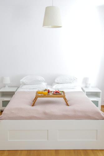 a white bed with a tray of food on it at Krokodyl Sport&Spa in Mielno