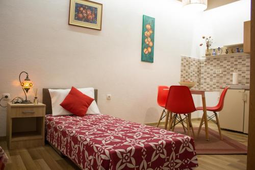 a bedroom with a bed and a table and chairs at Villa Acapulco in Mostar