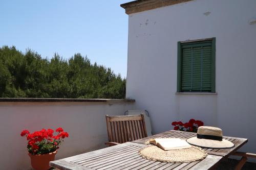 a table with two hats and a book on it at Agriturismo Francesca Stajano in Alezio