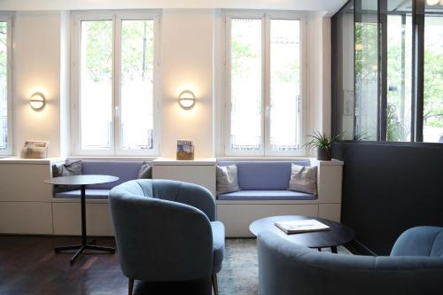a waiting room with chairs and a couch and windows at Stella Etoile in Paris