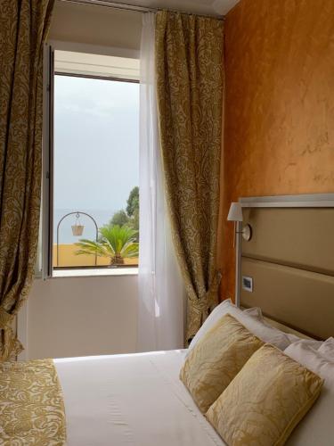 a bedroom with a bed and a large window at Hotel L'Ariana ISOLE EOLIE - UNA Esperienze in Leni