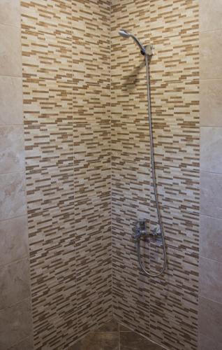 a shower in a bathroom with a brick wall at Apartment Petya in Velingrad