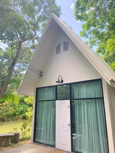 a small white house with a white door at Muaan Resort in Suphan Buri
