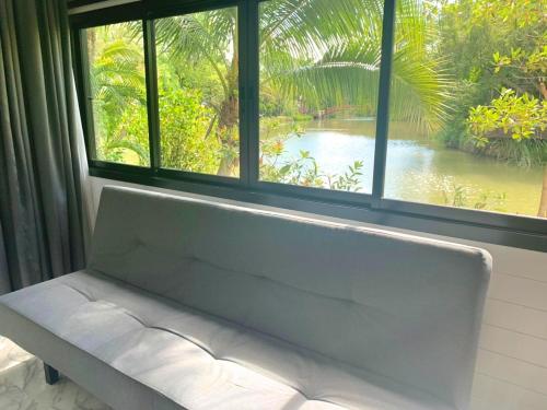 a bench sitting in front of a window at Muaan Resort in Suphan Buri