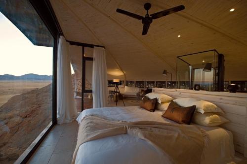 a bedroom with a bed and a large window at Desert Whisper in Solitaire