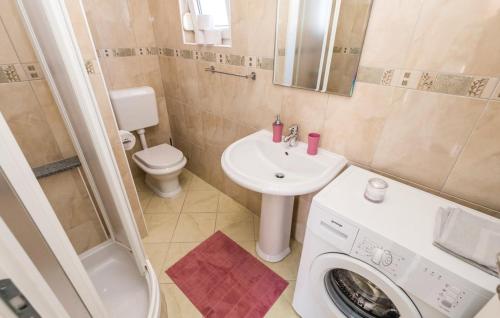 y baño con lavadora y lavamanos. en Apartman Dora, en Povljana