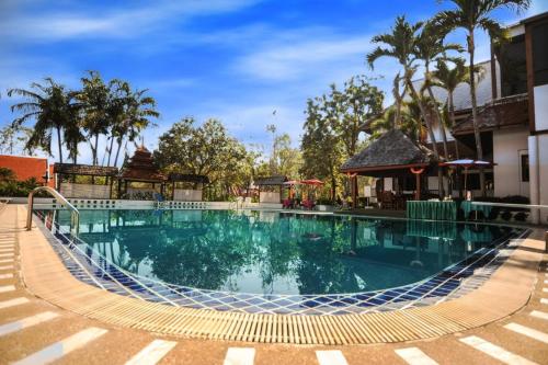 uma piscina num resort com palmeiras em Suan Bua Hotel & Resort em Ban Pong