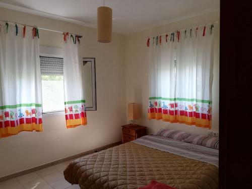 a bedroom with a bed and two windows at Don Bazilio Seahouse in Leptokaria